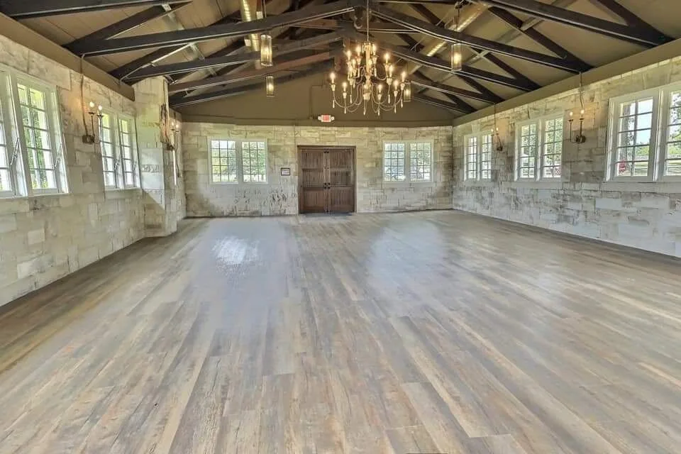 The Magnolia Chapel — historic stone event venue with exposed trusses and chandeliers